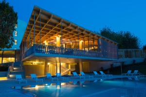 un edificio con sillas y piscina por la noche en OZADI Tavira Hotel, en Tavira