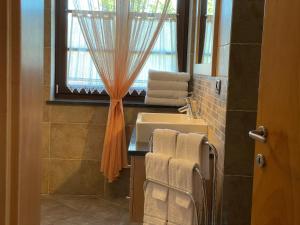 a bathroom with a sink and a window with towels at Agriturismo La Canonica in Brez