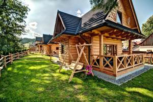 a log cabin with a playground in the yard at Osada HANKA Luxury in Witów