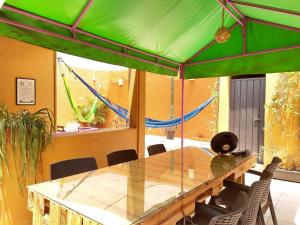 a dining room with a table and a green umbrella at Nova House in Mexico City