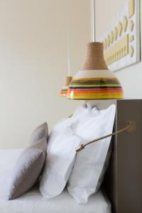 a lamp sitting on top of a bed with pillows at OZADI Tavira Hotel in Tavira
