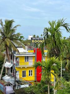 une maison jaune et rouge avec un panneau sur elle dans l'établissement Eden Homestay Alleppey, à Alappuzha