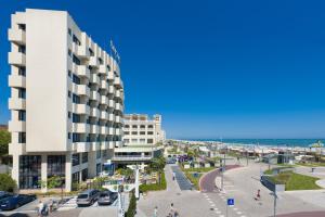 een groot wit gebouw naast het strand bij Hotel Baltic Riccione-Fronte Mare in Riccione