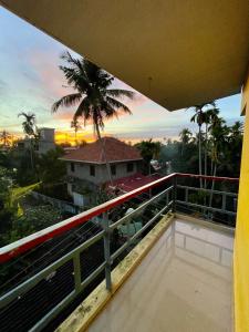 een balkon met uitzicht op een palmboom bij Eden Homestay Alleppey in Alleppey