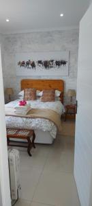 a bedroom with a bed and a picture of cows at Bergsig 2A in Clanwilliam