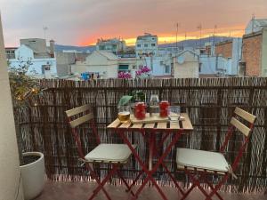 einen Tisch und Stühle auf einem Balkon mit Stadtblick in der Unterkunft Charming appartement in the heart of Barcelona in Barcelona