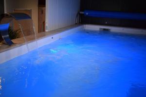a large swimming pool with a water fountain at Gite 5 pers avec 2h espace bien-être privatisé inclus dans le prix de la nuit 80m2 de détente in Équilly