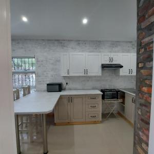 a kitchen with white cabinets and a counter top at Bergsig 2A in Clanwilliam