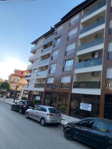 een groep auto's geparkeerd voor een gebouw bij LYNX Apartments in Ohrid