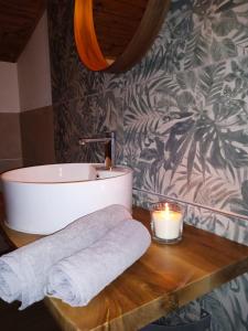 baño con lavabo y una vela sobre una mesa de madera en La Mansarda en Lozzo Cadore