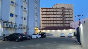 a parking lot with cars parked in front of a large building at الرؤية للشقق المخدومة - إقتصادي - Alruwyah For Serviced Apartments - Economy in Najran