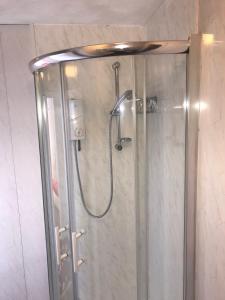a shower with a glass door in a bathroom at On The Beach Apartments in Blackpool