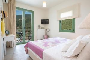a bedroom with a bed and a large window at Ktima Aniforeli Luxury Villas in Sivota