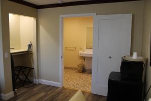 a room with a bathroom with a sink and a mirror at Imperial Inn Oakland in Oakland