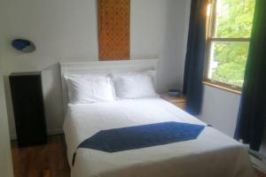 1 dormitorio con 1 cama con manta azul y blanca en L'Alcôve des Céramistes en Waterloo