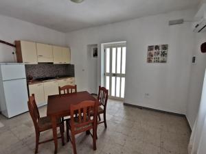 a kitchen with a table and chairs and a refrigerator at Casa Vacanze La Cantinetta Via Montesanto in Peschici