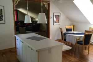 a kitchen and living room with a table and chairs at L'Alcôve des Céramistes in Waterloo