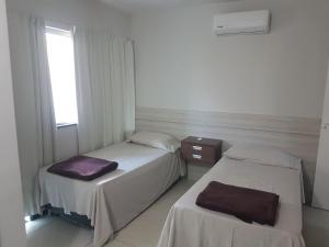 two beds in a room with a window at Mirante de Escarpas 801 in Capitólio