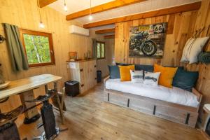 Habitación con cama en una cabaña de madera en Cabanes dans les arbres avec spa Lot et Dordogne en Lamothe-Fénelon