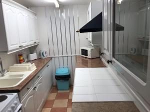 a kitchen with white cabinets and a sink and a microwave at On The Beach Apartments in Blackpool +113 photos
