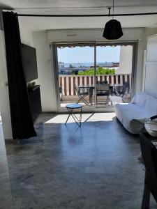 a living room with a bed and a view of a balcony at Superbe appartement plage SAINT-LAURENT DU VAR in Saint-Laurent-du-Var