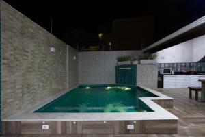 a swimming pool in the middle of a house at Peruibiza Pousada in Peruíbe