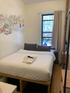 sypialnia z 2 łóżkami i oknem w obiekcie Chelsea Rooms NYC w Nowym Jorku