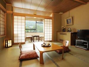a living room with a table and chairs and a television at Gion Fukuzumi in Kyoto