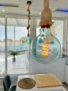 a glass light bulb hanging from a ceiling at Villa Blanca Tenerife - Atico Loft in San Isidro