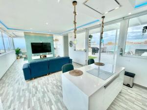 a living room with a blue couch and a tv at Villa Blanca Tenerife - Atico Loft in San Isidro