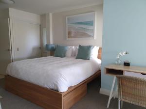 a bedroom with a large bed and a desk at Peaceful Mount Studio Moments to Beach & Downtown in Mount Maunganui