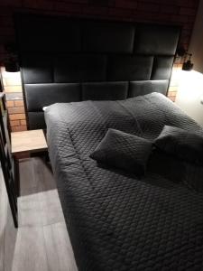 duże łóżko z czarnym zagłówkiem w pokoju w obiekcie Czerwona Cegła Apartament w Zielonej Górze
