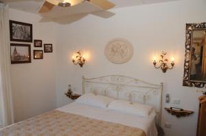 a bedroom with a white bed and a ceiling fan at La casa di Luna in San Benedetto del Tronto