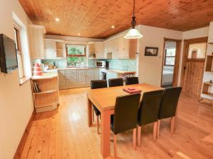 a kitchen with a wooden dining table and chairs at Silver Birch in Cuar an Chláir