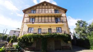 d'un grand bâtiment jaune avec des balcons en haut. dans l'établissement Вілла Східниця, à Skhidnitsa