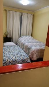 ein kleines Zimmer mit 2 Betten und einem Fenster in der Unterkunft Apart Guest Iquique in Iquique