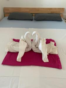 two towel swans making a heart on a bed at Apartments Michael & Petra , Omisalj, Insel Krk, Kroatien in Omišalj