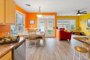 uma cozinha com paredes cor de laranja e uma mesa e cadeiras em The Lucky Beach House, The Most Popular Beach House in Atlantic City! WOW! em Atlantic City