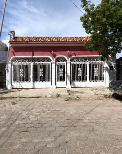um portão branco em frente a um edifício vermelho em Mini Hostal Cultural de Mazatlán em Mazatlán