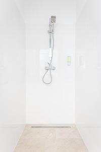 een douche in een witte badkamer met een houten vloer bij Space Home Apartment - City Center in Wenen