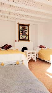 een witte kamer met 2 bedden en een open haard bij Dar Massaneh in Essaouira