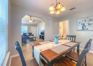 Un comedor y una sala de estar con mesa y sillas. en Luminous & Pristine, Spacious and Serene!, en Tallahassee