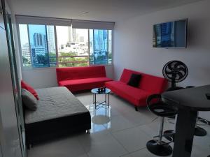 Apartamento Lorenita في كارتاهينا دي اندياس: غرفة معيشة مع أريكة حمراء وطاولة