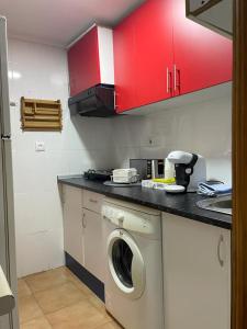 cocina con lavadora y armarios rojos en Apartamento de 1 dormitorio en buena ubicación en Albacete