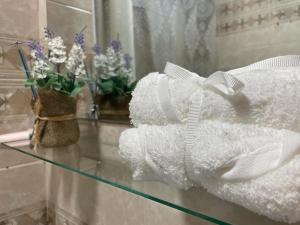 a glass table with white towels and flowers on it at Apartamento de 1 dormitorio en buena ubicación in Albacete