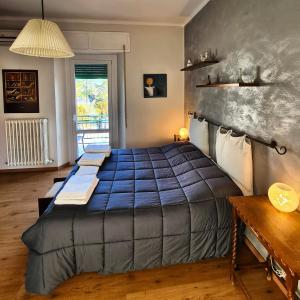Conero Apartments في كاميرانو: غرفة نوم بسرير كبير مع بطانية زرقاء
