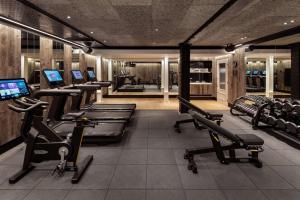 a gym with rows of treadmills and exercise machines at Radisson Blu Hotel, London Bloomsbury in London