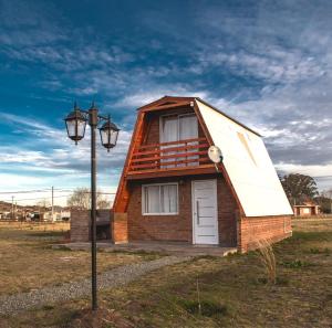 a small house with a white door and a street light at Los Lirios in Sierra de la Ventana