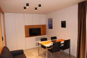 a dining room with a table and chairs and a television at La casetta di Nonna Paola in Palazzolo Acreide