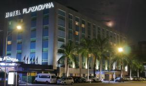 ein Hotel in der Nacht mit Autos auf einem Parkplatz in der Unterkunft Hotel Plaza Diana in Guadalajara